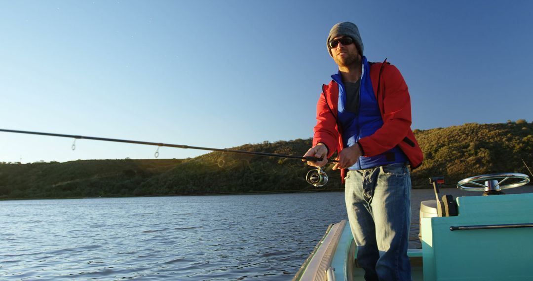 Caucasian man enjoys fishing on a serene lake, with copy space - Free Images, Stock Photos and Pictures on Pikwizard.com