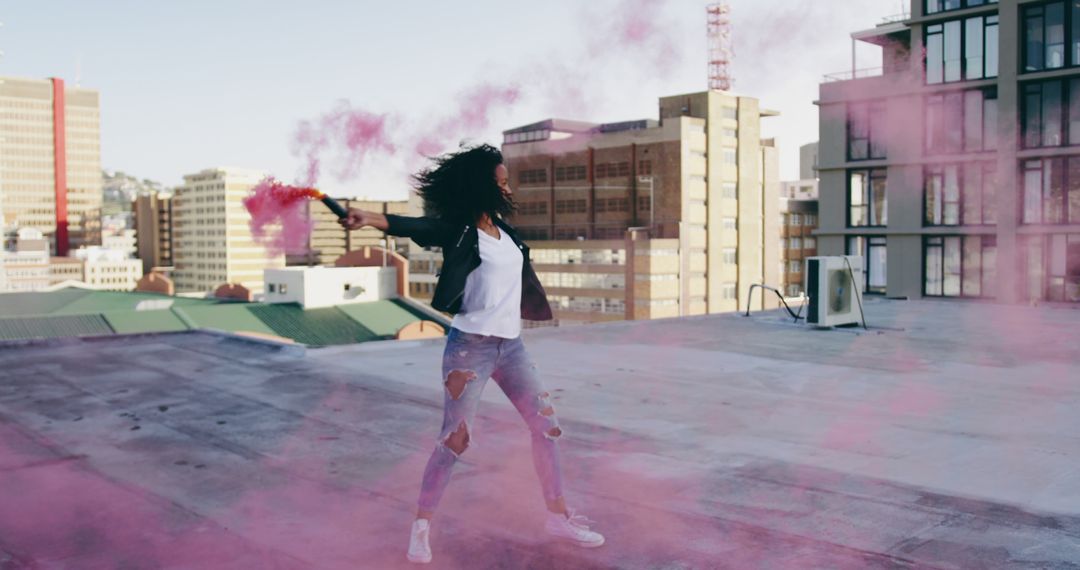 Woman Waving Pink Smoke Bomb on Urban Rooftop at Sunset - Free Images, Stock Photos and Pictures on Pikwizard.com