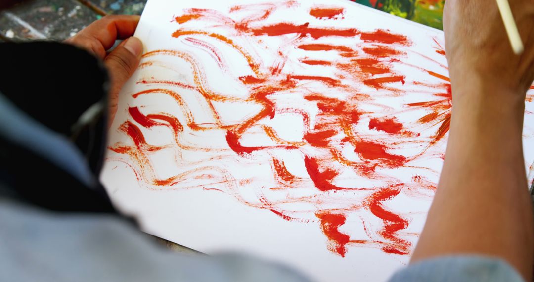 An individual is creating an abstract red painting on paper, with copy space - Free Images, Stock Photos and Pictures on Pikwizard.com
