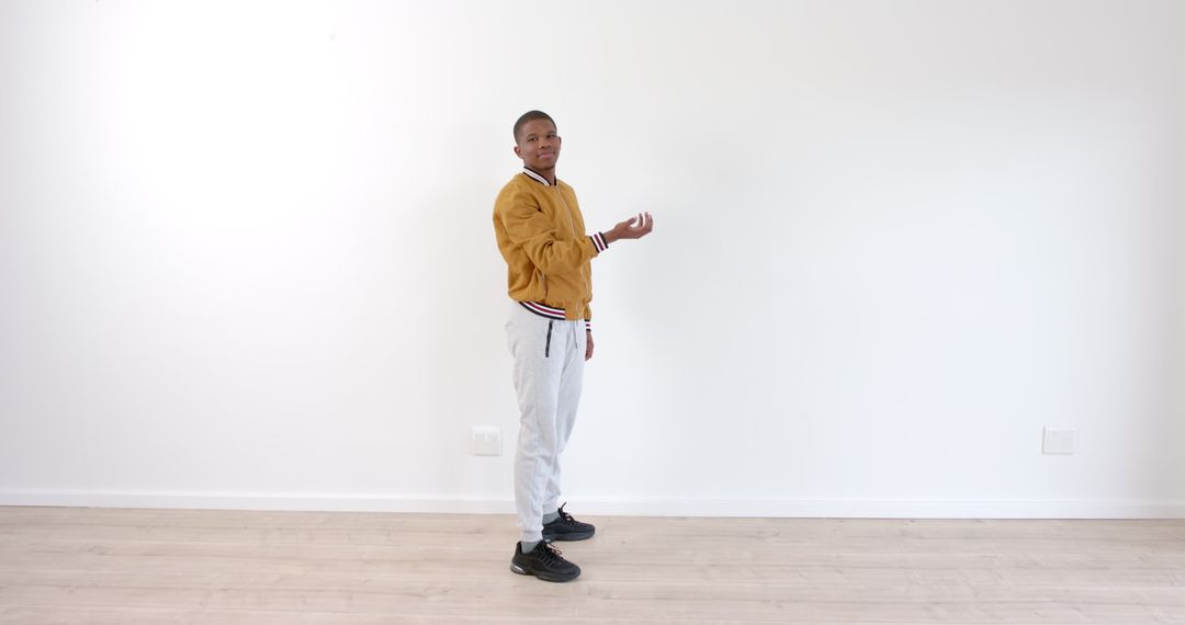 Young Boy Practicing Mime Skills Against White Background Indoors