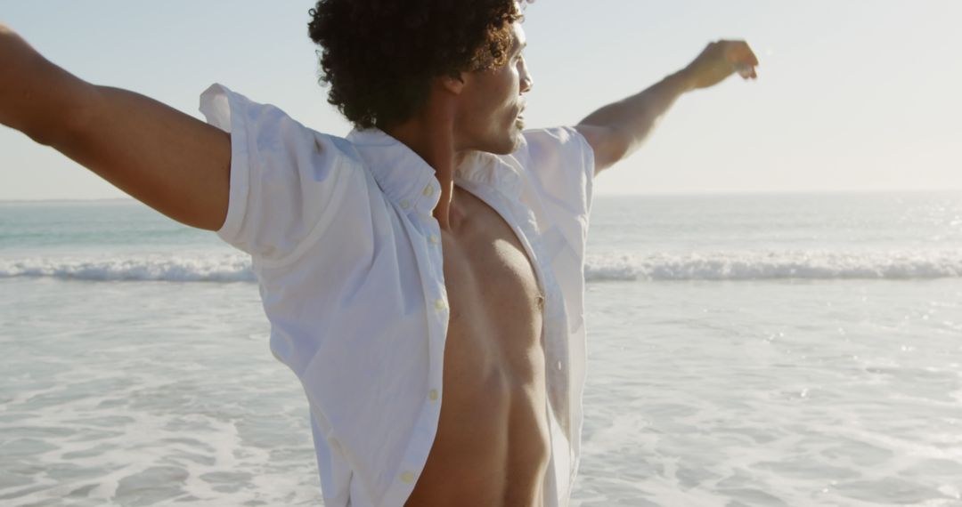 Carefree Man with Outstretched Arms Savoring Beach vVew - Free Images, Stock Photos and Pictures on Pikwizard.com