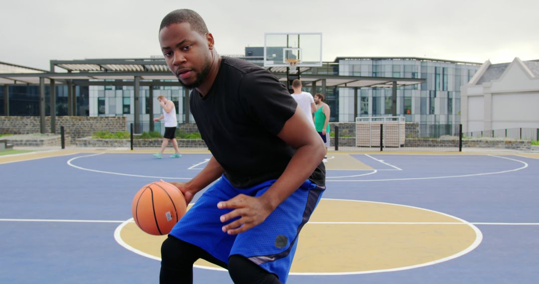 Focused Basketball Player Dribbling on Outdoor Court - Free Images, Stock Photos and Pictures on Pikwizard.com