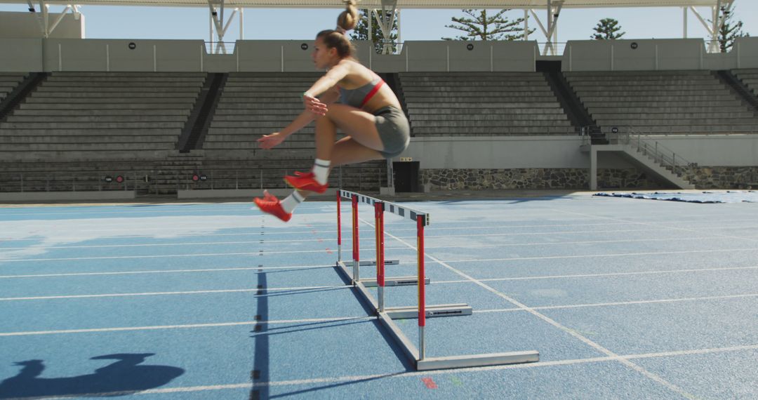 Female Athlete Clearing Hurdle in Track Training - Free Images, Stock Photos and Pictures on Pikwizard.com