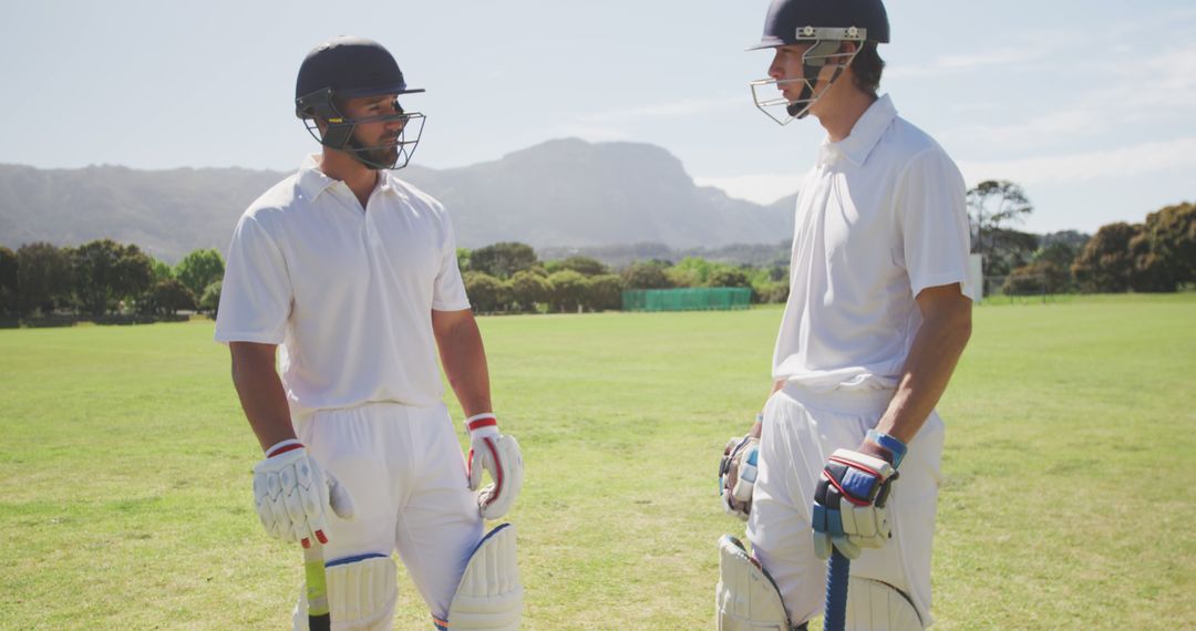 Two Male Cricketers Discussing Strategy During Game on Sunny Day - Free Images, Stock Photos and Pictures on Pikwizard.com