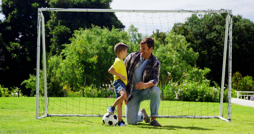 Father and Son Enjoying Soccer Practicing Outdoors in Goal - Free Images, Stock Photos and Pictures on Pikwizard.com