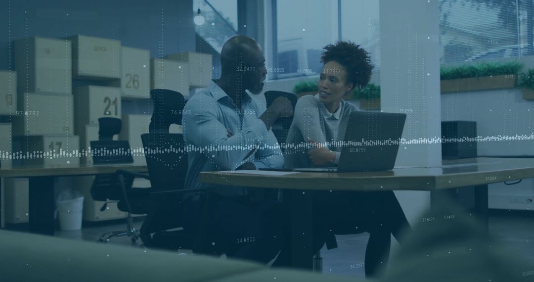 Office Professionals Analyzing Data on Laptop in Modern Workplace