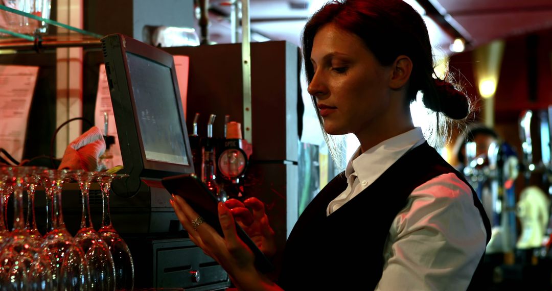 Waitress Taking Order on Tablet in Dimly Lit Bar - Free Images, Stock Photos and Pictures on Pikwizard.com