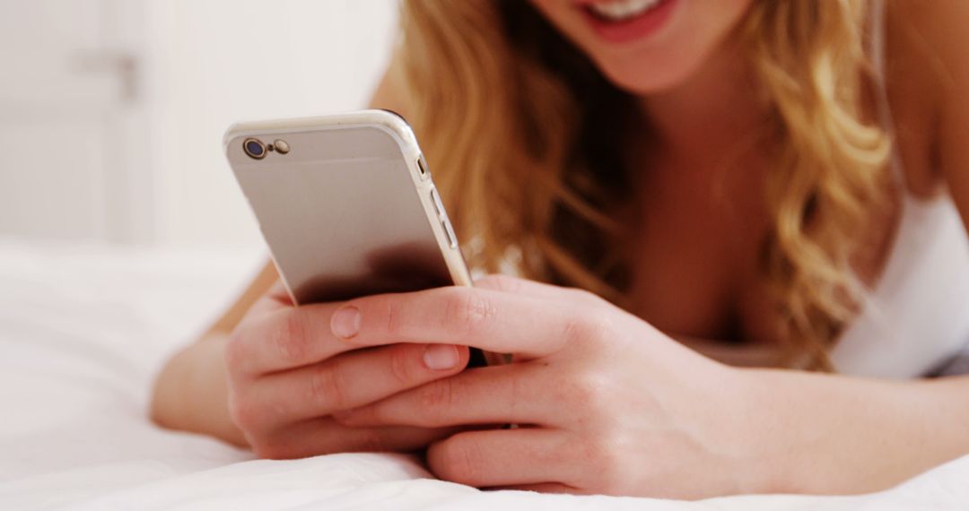 Woman Smiling While Using Smartphone in Bed - Free Images, Stock Photos and Pictures on Pikwizard.com