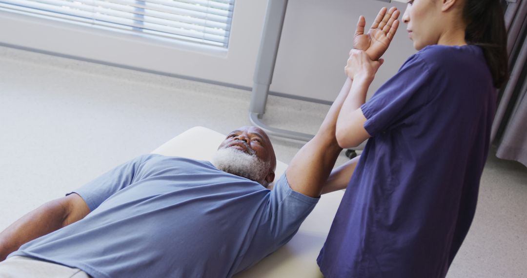 Physiotherapist Assisting Senior Patient with Arm Exercises in Clinic - Free Images, Stock Photos and Pictures on Pikwizard.com