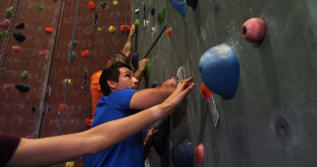 Young Adults Enjoying Indoor Rock Climbing Session - Free Images, Stock Photos and Pictures on Pikwizard.com