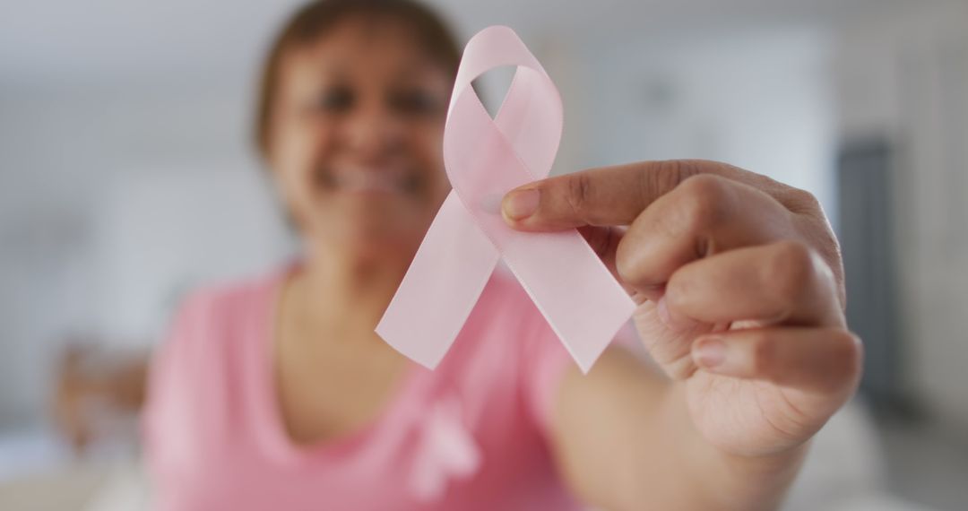 Close Up of Woman Holding Pink Breast Cancer Awareness Ribbon - Free Images, Stock Photos and Pictures on Pikwizard.com