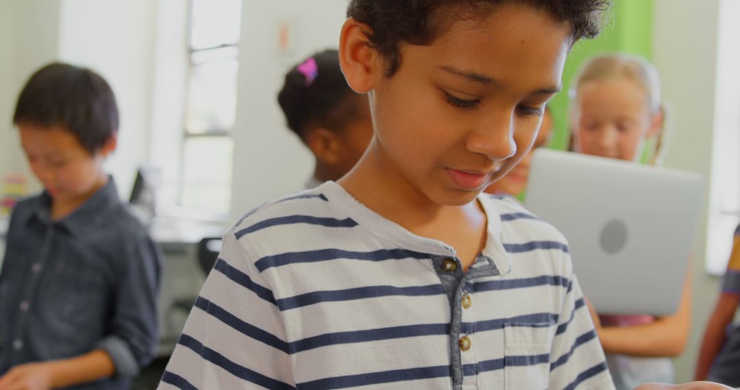 Focused School Boy Using Tablet in Classroom Environment