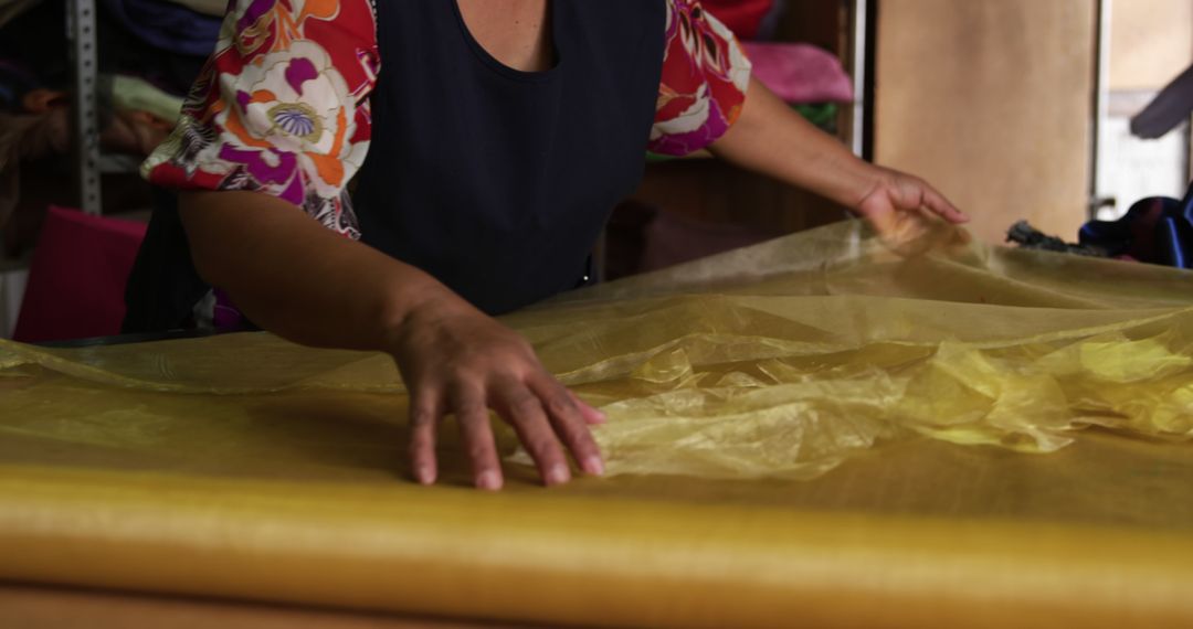 Woman Handling Yellow Silk Fabric in Workshop - Free Images, Stock Photos and Pictures on Pikwizard.com