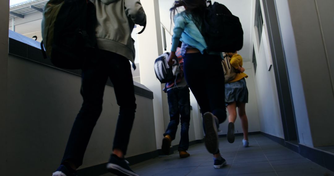 Excited Students Running Down School Hallway with Backpacks