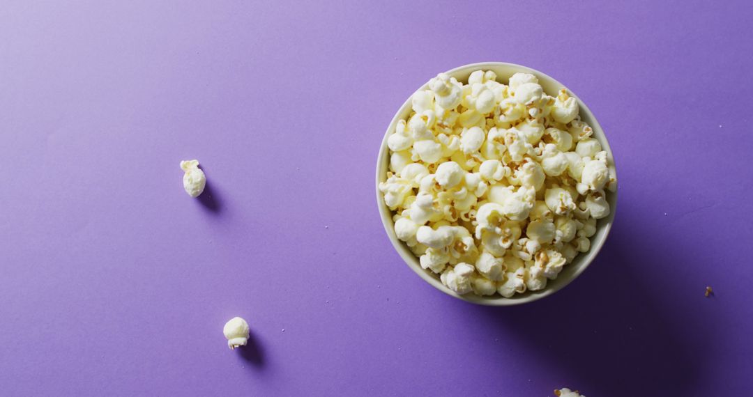 Top View of Popcorn Bowl on Purple Background with Copy Space - Free Images, Stock Photos and Pictures on Pikwizard.com