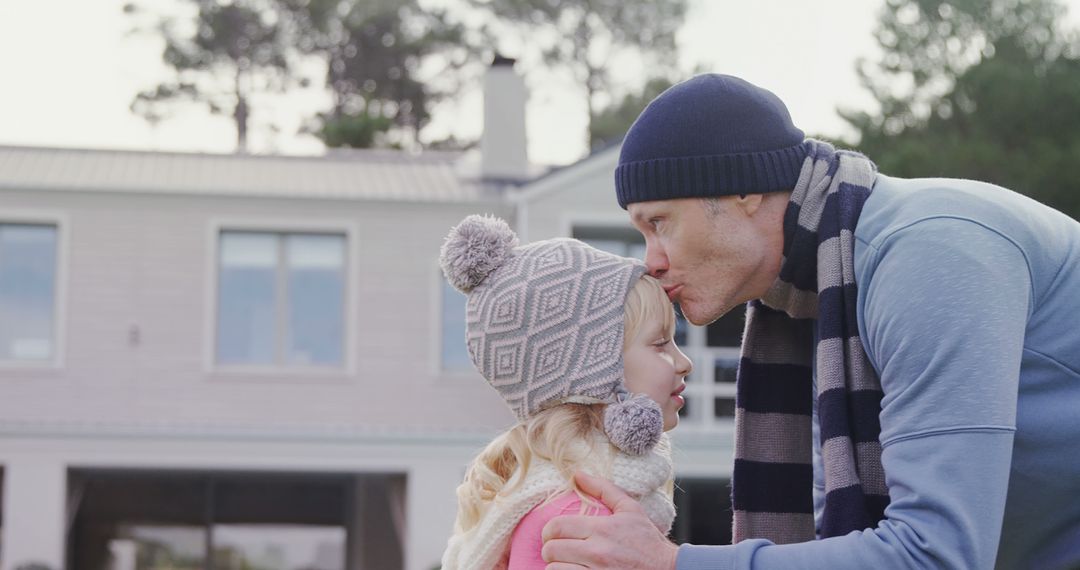 Father Kissing Daughter Forehead Outdoors During Winter - Free Images, Stock Photos and Pictures on Pikwizard.com