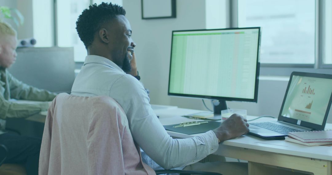 Professional Worker Analyzing Data on Monitor in Open Office Setup