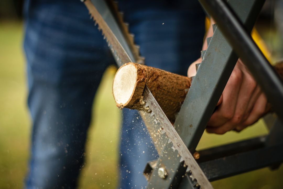 Close-up of Person Sawing Wooden Log with Hand Saw Outdoors - Free Images, Stock Photos and Pictures on Pikwizard.com