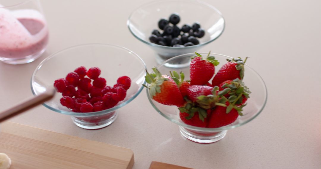 Glass Bowls with Strawberries, Raspberries, and Blueberries on Countertop