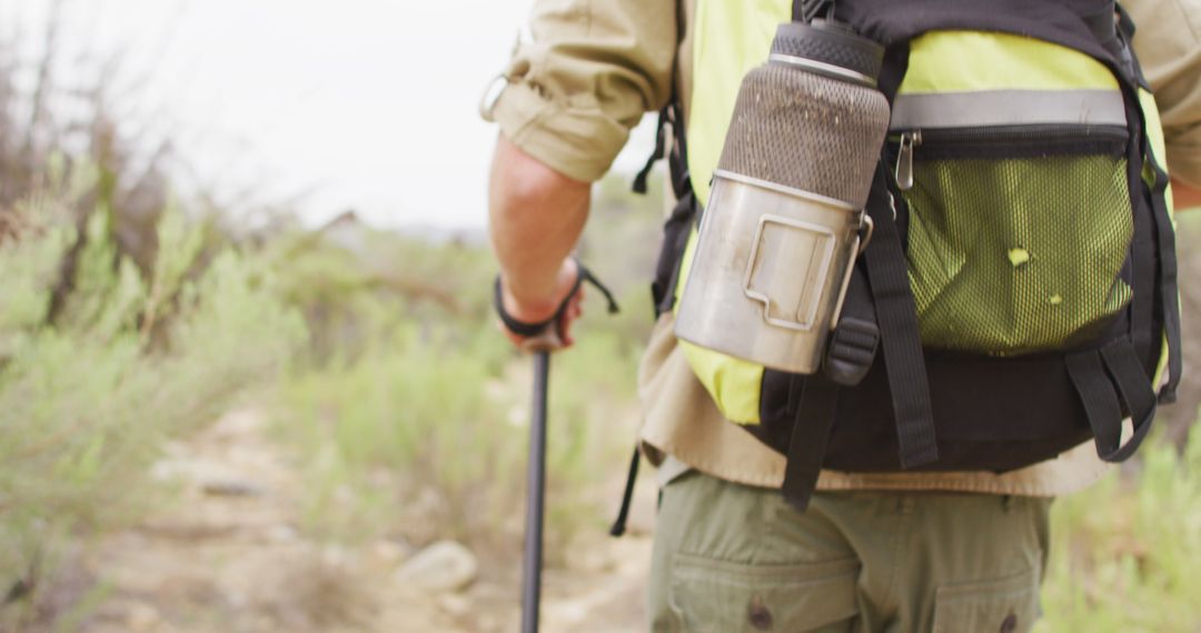 Survivalist Exploring Wilderness with Backpack and Walking Poles