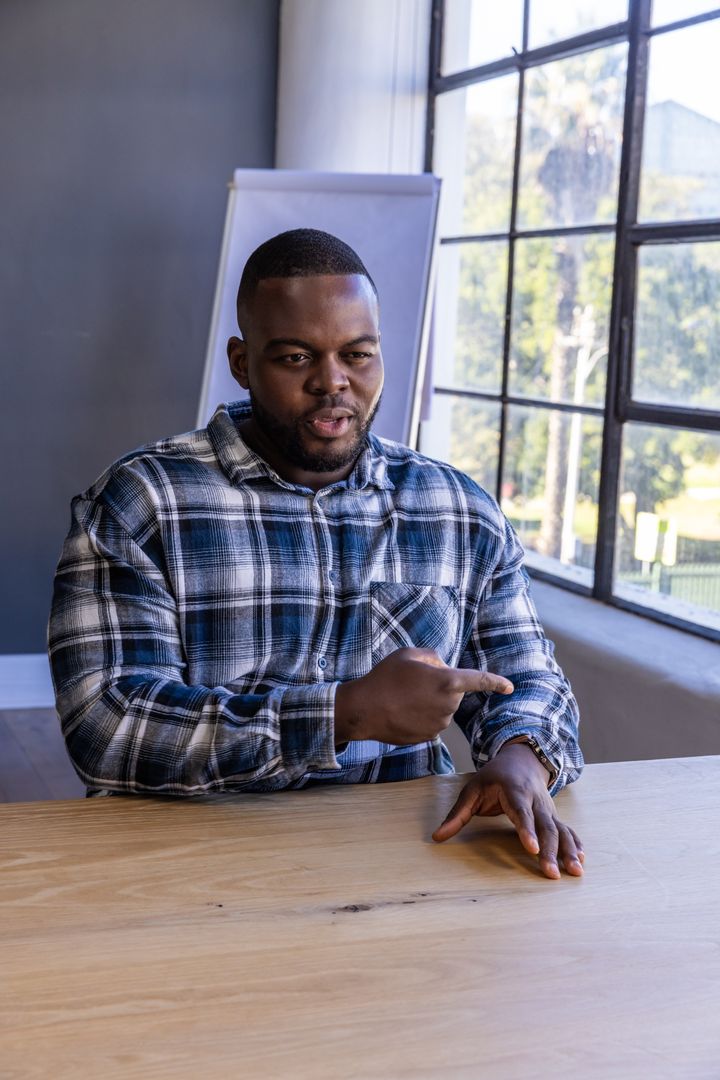 Confident Businessman Emphasizing Time at Modern Workplace