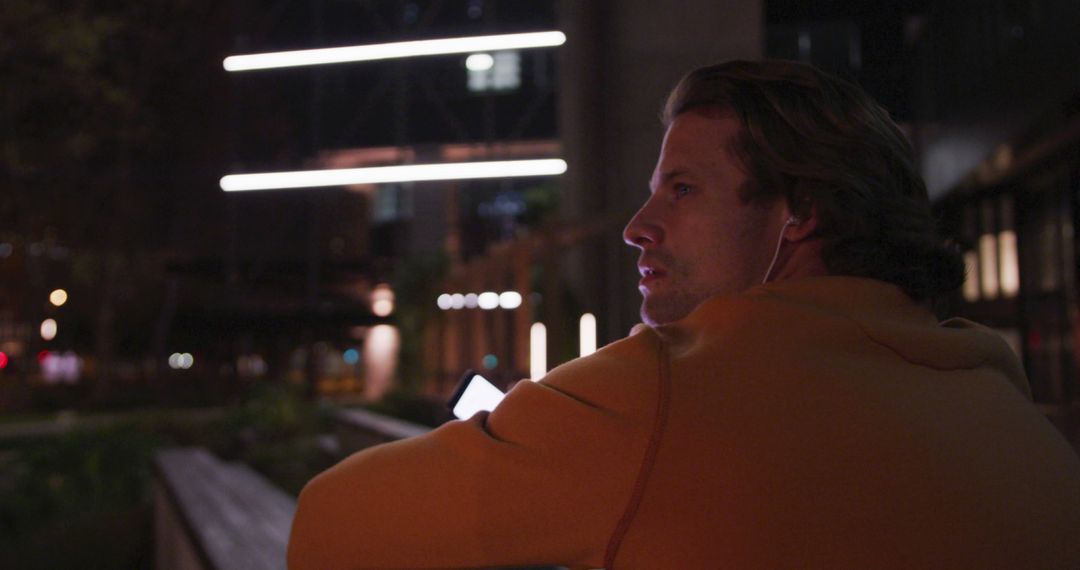 Man Relaxing Outside at Night with Earphones In - Free Images, Stock Photos and Pictures on Pikwizard.com