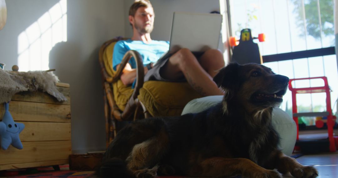 Man Relaxing While Working from Home with Dog in Living Room - Free Images, Stock Photos and Pictures on Pikwizard.com