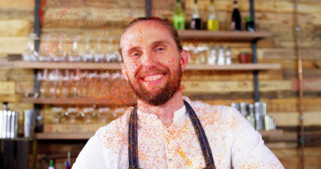 Smiling bartender tossing orange spice over rustic bar counter during craft mixology