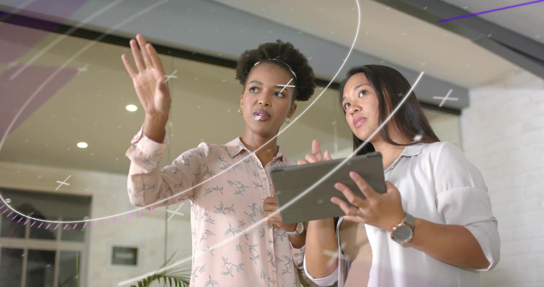 Businesswomen Discussing Digital Interface with Tablet in Modern Office