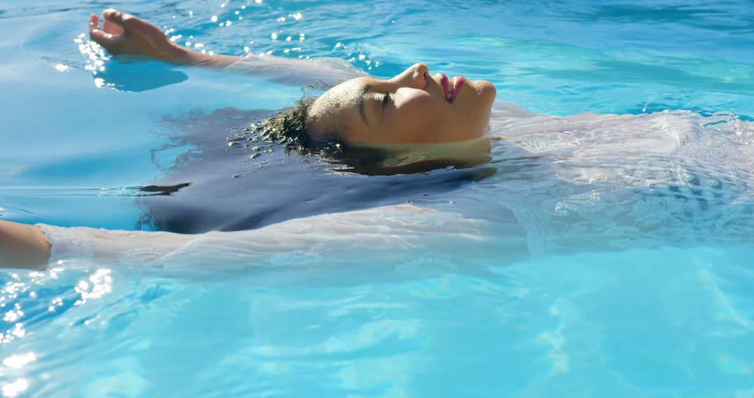 Serene Woman Floating in Clear Blue Pool - Free Images, Stock Photos and Pictures on Pikwizard.com