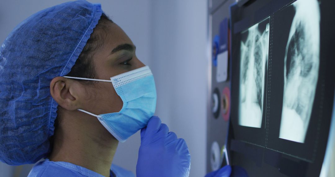 Healthcare Worker Analyzing X-ray Image with Protective Gear - Free Images, Stock Photos and Pictures on Pikwizard.com