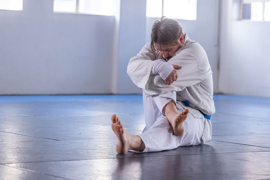 Martial Artist in Meditation Pose on Dojo Mat near Windows