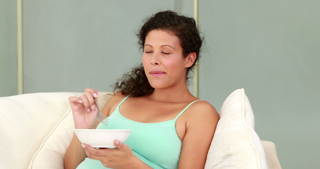 Pregnant Woman Enjoying Healthy Meal on Comfortable Couch - Free Images, Stock Photos and Pictures on Pikwizard.com