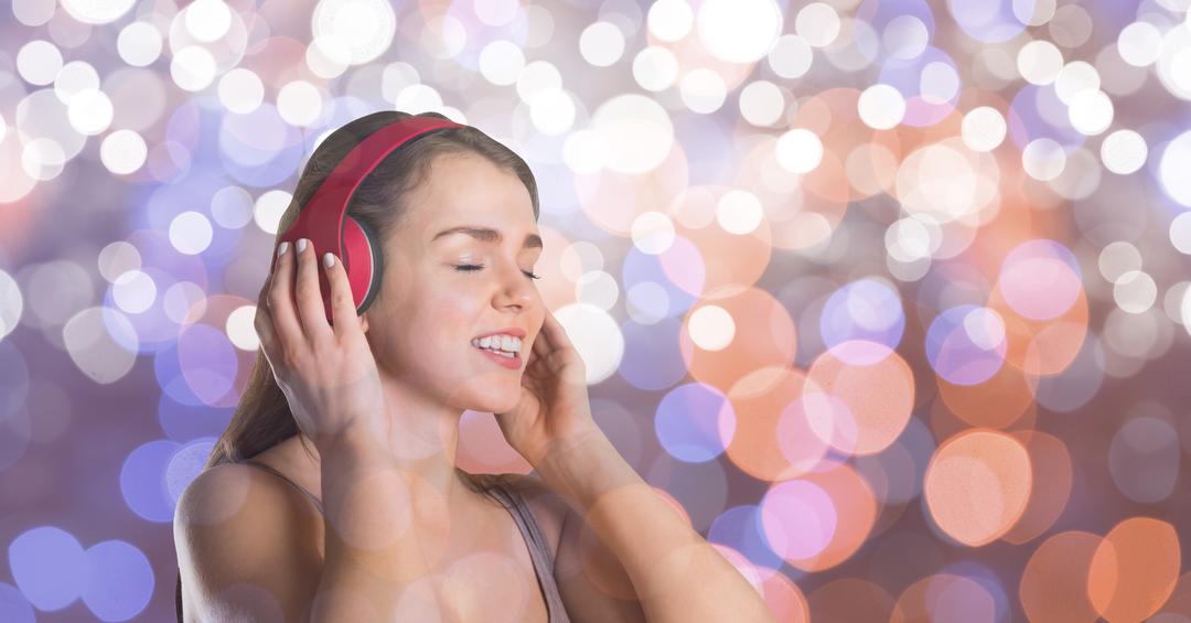 Music artist wearing headphones while singing over bokeh - Free Images, Stock Photos and Pictures on Pikwizard.com