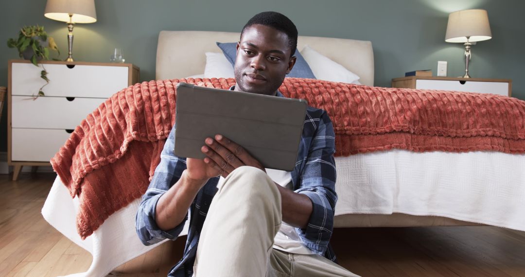 Man Using Tablet in Cozy Bedroom Retreat for Leisure