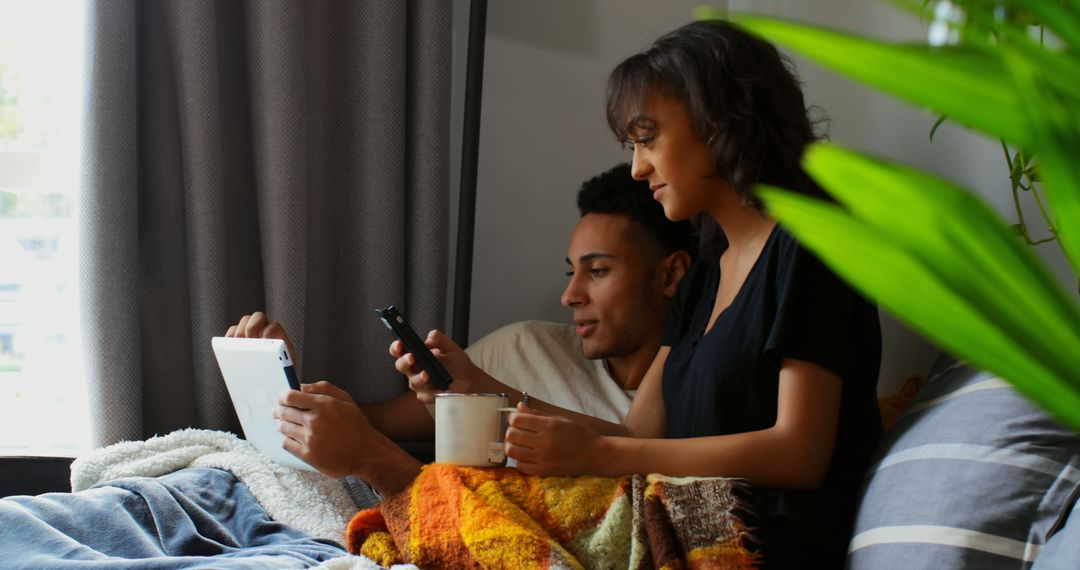 Asian Couple Relaxing with Devices at Home