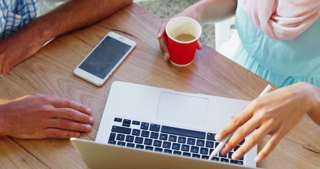 Collaborative Office Work with Laptop and Coffee