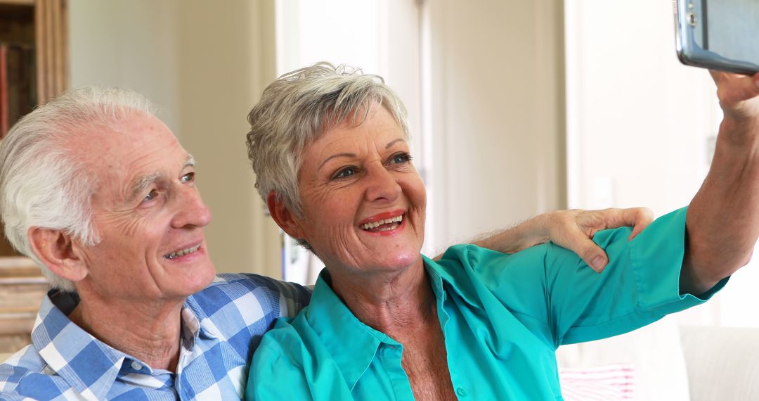 Smiling Senior Couple Taking Selfie at Home