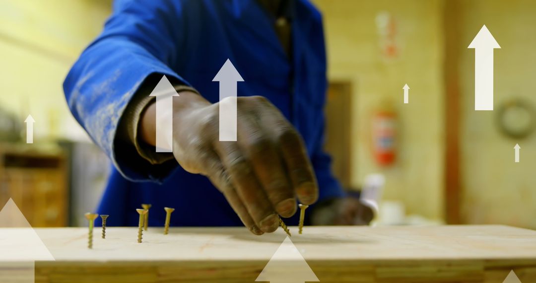 Focused Worker Screwing Nails with Arrow Graphics Representing Growth