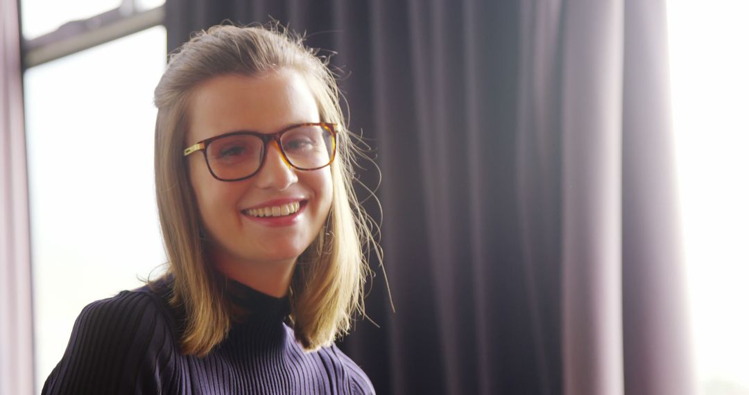 Smiling Young Woman Wearing Glasses in Well-Lit Room - Free Images, Stock Photos and Pictures on Pikwizard.com