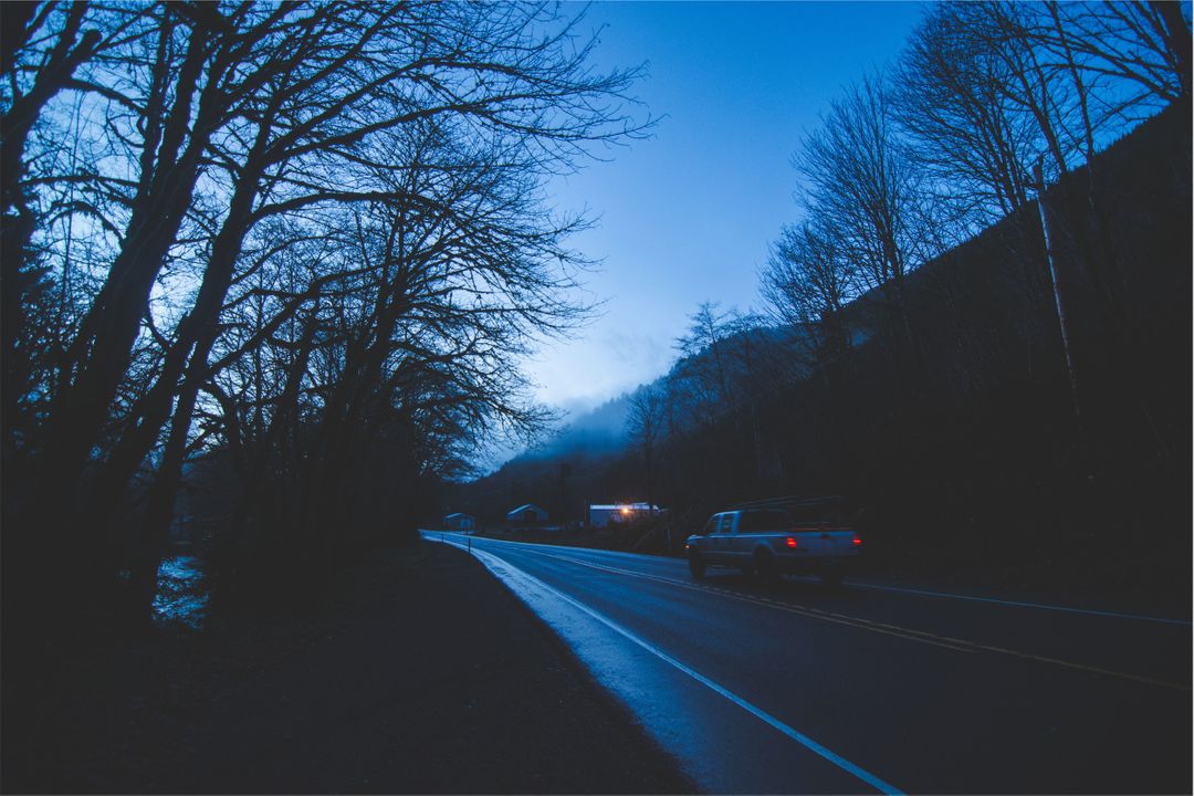 Misty Evening Country Road with Car Under Blue Twilight Sky - Free Images, Stock Photos and Pictures on Pikwizard.com