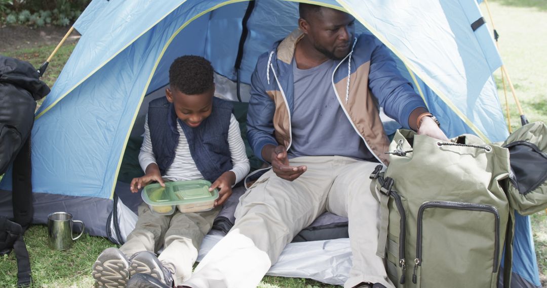 Father and Son Enjoy Camping Experience with Tent Picnic