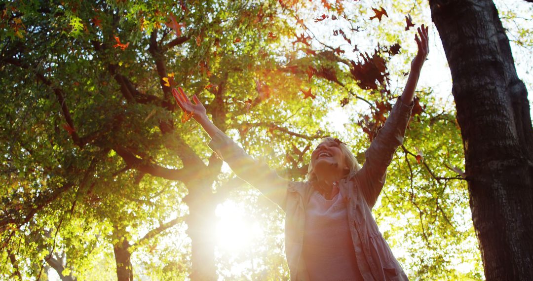 Happy Mature Woman Enjoying Nature in Sunlit Forest - Free Images, Stock Photos and Pictures on Pikwizard.com