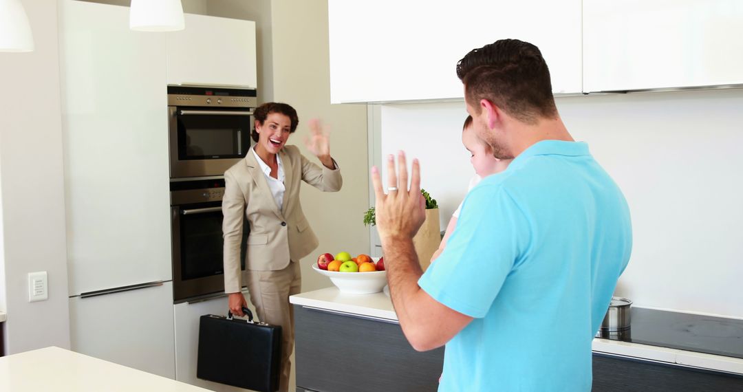 Businesswoman waving goodbye to family in modern kitchen - Free Images, Stock Photos and Pictures on Pikwizard.com