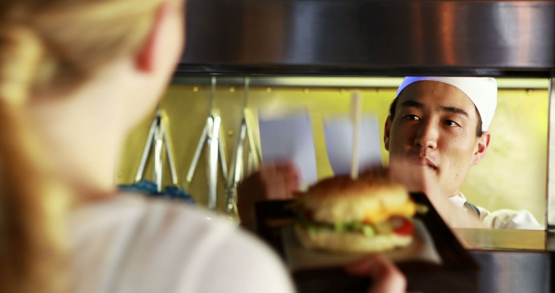 Chef Serving Fast Food Burger to Customer at Counter - Free Images, Stock Photos and Pictures on Pikwizard.com