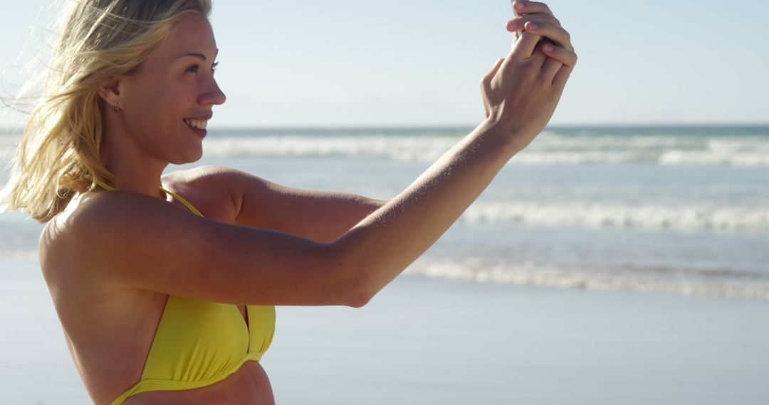 Woman Taking Selfie at Beach in Yellow Bikini - Free Images, Stock Photos and Pictures on Pikwizard.com