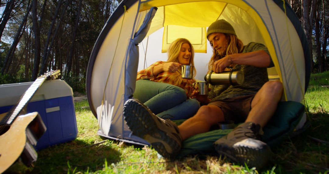 Young Couple Enjoying Hot Drink in Tent While Camping in Forest - Free Images, Stock Photos and Pictures on Pikwizard.com