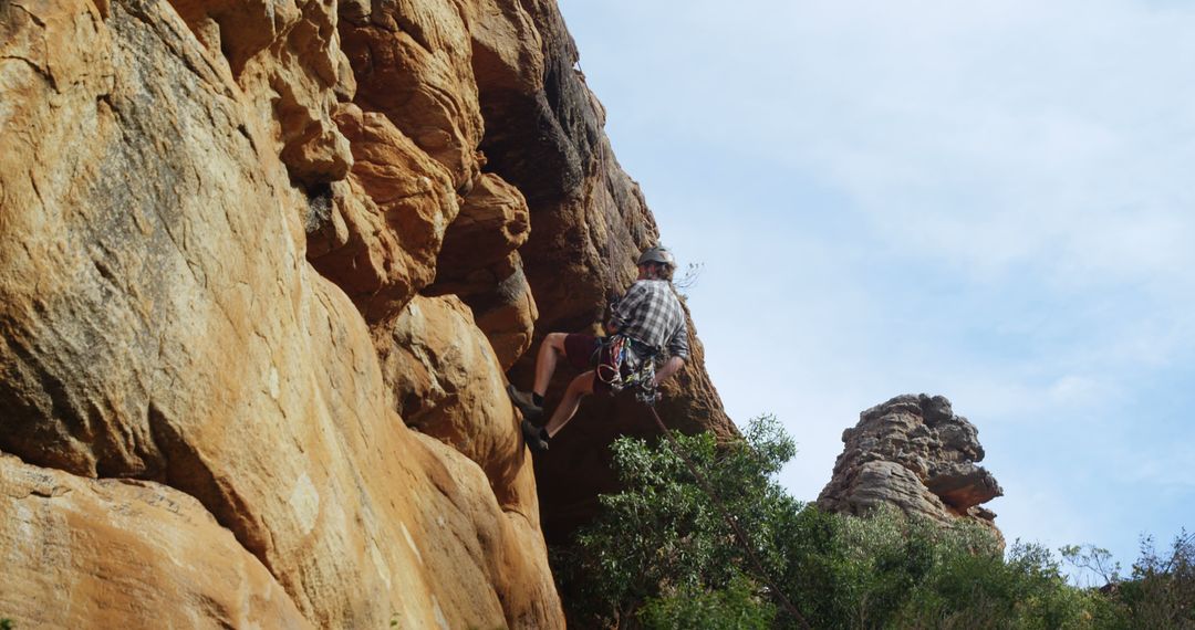 Climber Ascending Rocky Cliff Face Outdoors - Free Images, Stock Photos and Pictures on Pikwizard.com