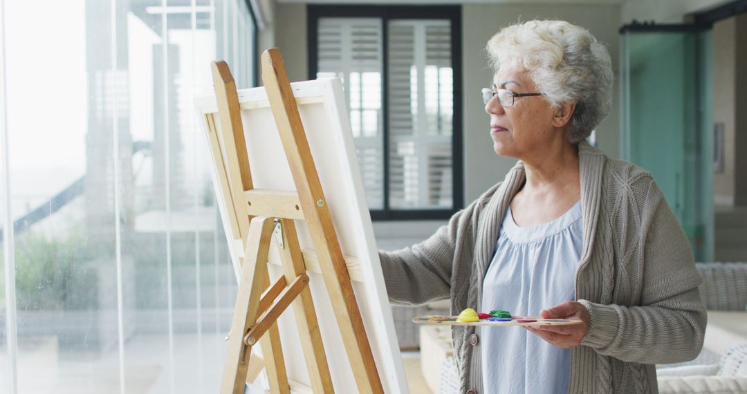 Elderly Woman Painting on Canvas in Bright Studio - Free Images, Stock Photos and Pictures on Pikwizard.com