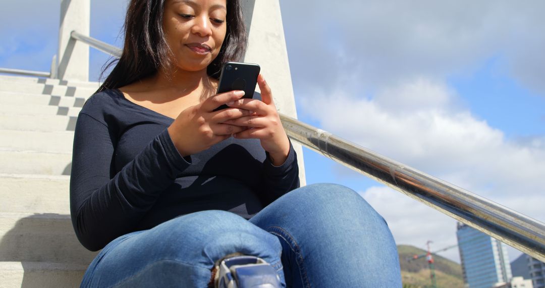 Young Woman Sitting on Outdoor Stairs Using Smartphone - Free Images, Stock Photos and Pictures on Pikwizard.com